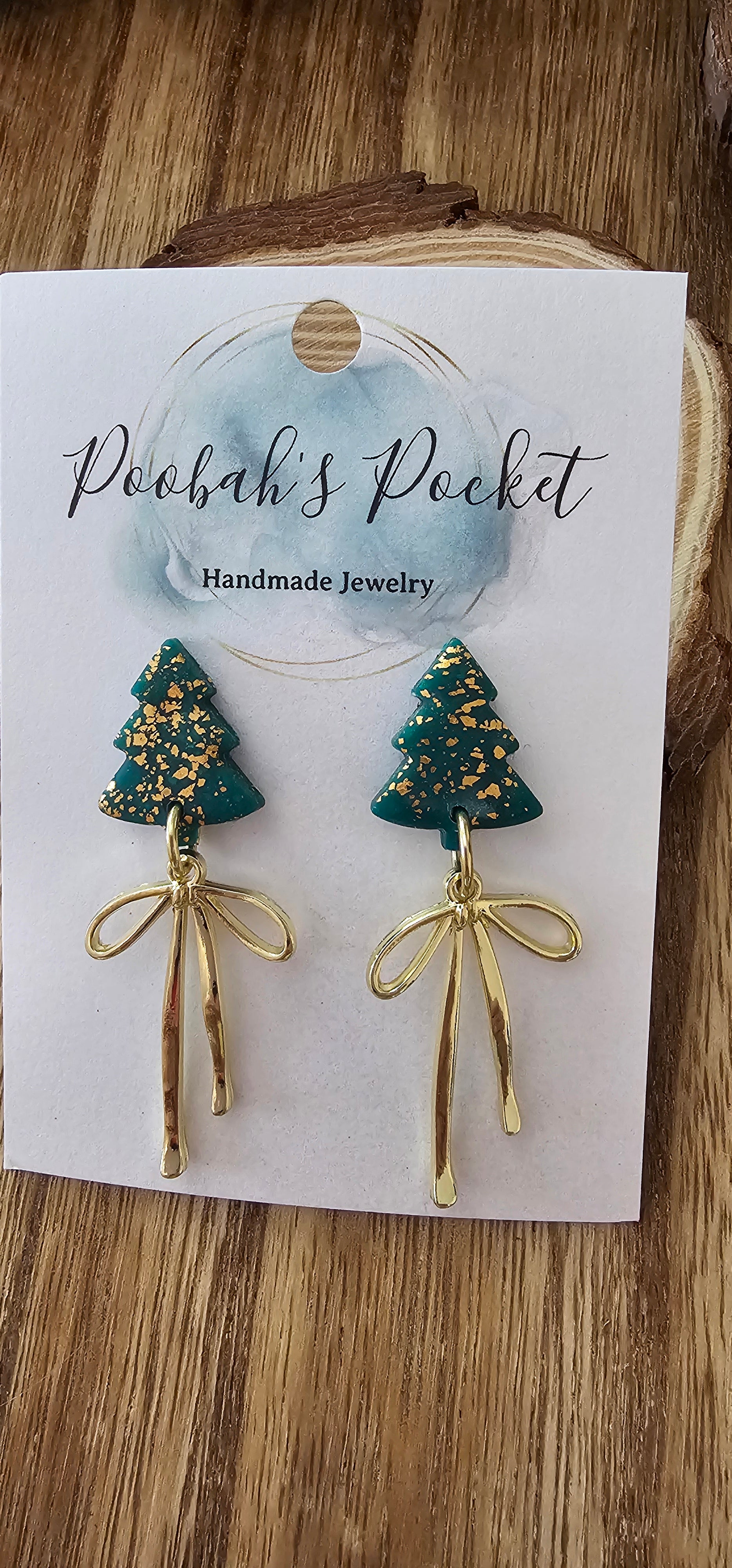 Christmas tree-shaped earrings with gold ribbons.